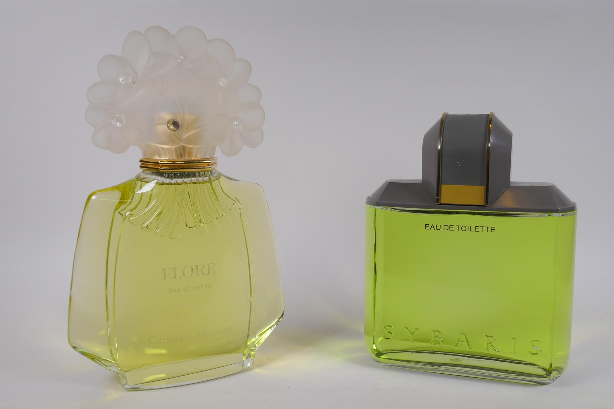 An oversized Carolina Herrera Flore perfume display bottle, and a similar Antonio Puig Sybaris