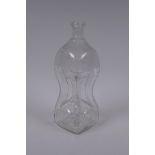 An antique glass bottle of pinched waist form and etched decoration, 28cm high