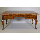 A continental walnut and marquetry inlaid bureau plat, with five drawers, raised on cabriole