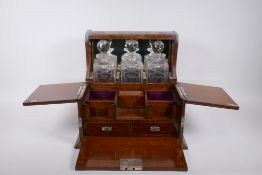 A Victorian oak and silver plated three bottle tantalus, opening to reveal fitted compartments,