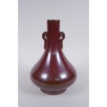 A Chinese copper red glazed porcelain vase with two handles, impressed Qianlong seal mark to base,