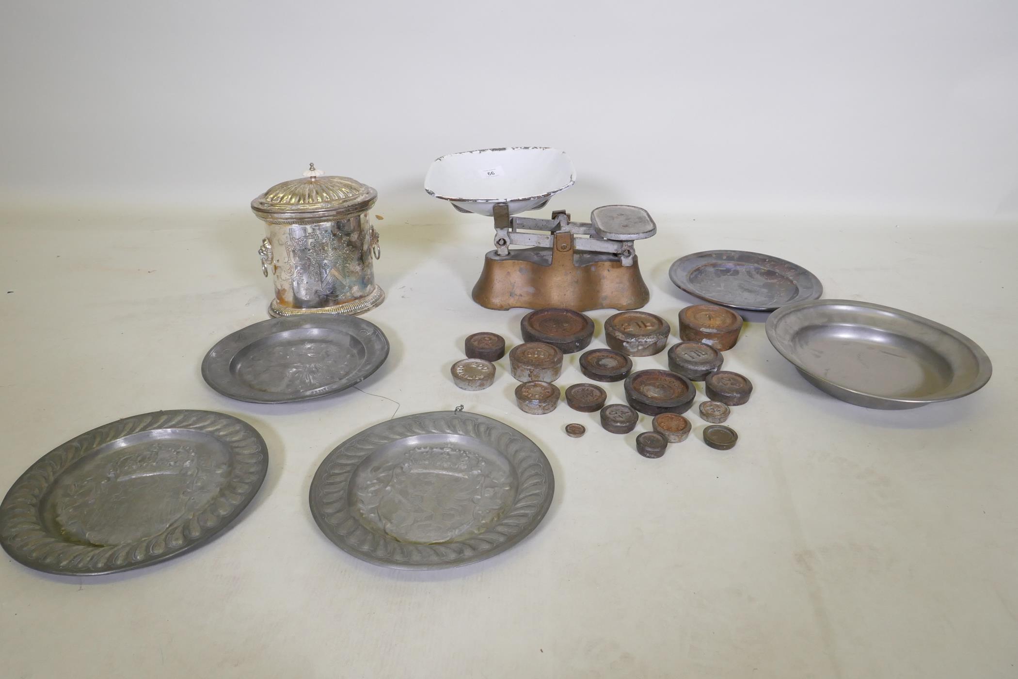 A set of antique weighing scales and weights, a pair of pewter plates with heraldic designs, a C19th
