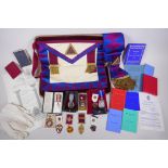 A collection of Masonic regalia to include an apron, sash, assorted medals (some silver) and a