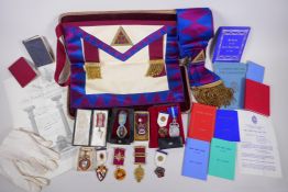 A collection of Masonic regalia to include an apron, sash, assorted medals (some silver) and a