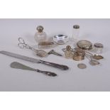 A collection of silver top scent bottles, spoons, a heart shaped pill box, silver half dollar,