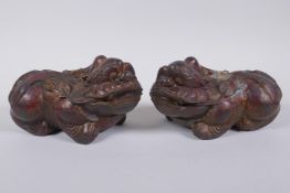 A pair of Chinese filled bronze kylin, with the remnants of gilt and copper patina, impressed 4