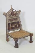 An antique Indian Pidha low chair with folding back, brass and iron mounts and webbed seat