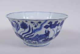 A blue and white porcelain steep sided bowl with lobed rim, decorated with carp in a lotus pond,