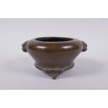 A Chinese bronze censer on tripod supports with two fo dog mask handles, impressed mark to base,