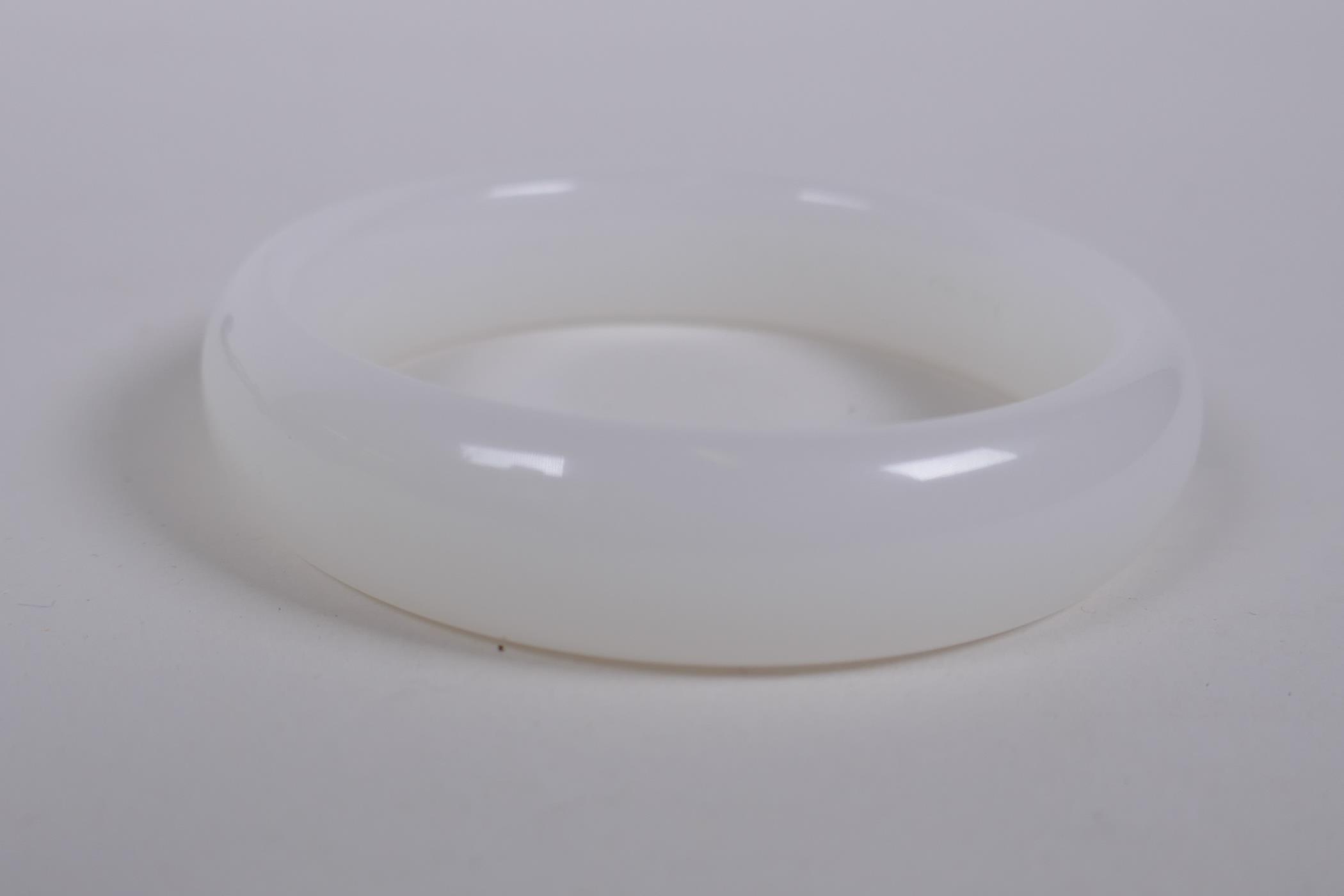 A white hardstone bangle, 8cm diameter