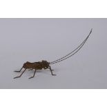A Japanese style bronze okimono grass hopper with articulated limbs, 14cm long