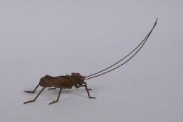 A Japanese style bronze okimono grass hopper with articulated limbs, 14cm long