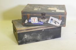 A vintage metal strapped travel trunk adorned with various cabin labels, together with a large metal