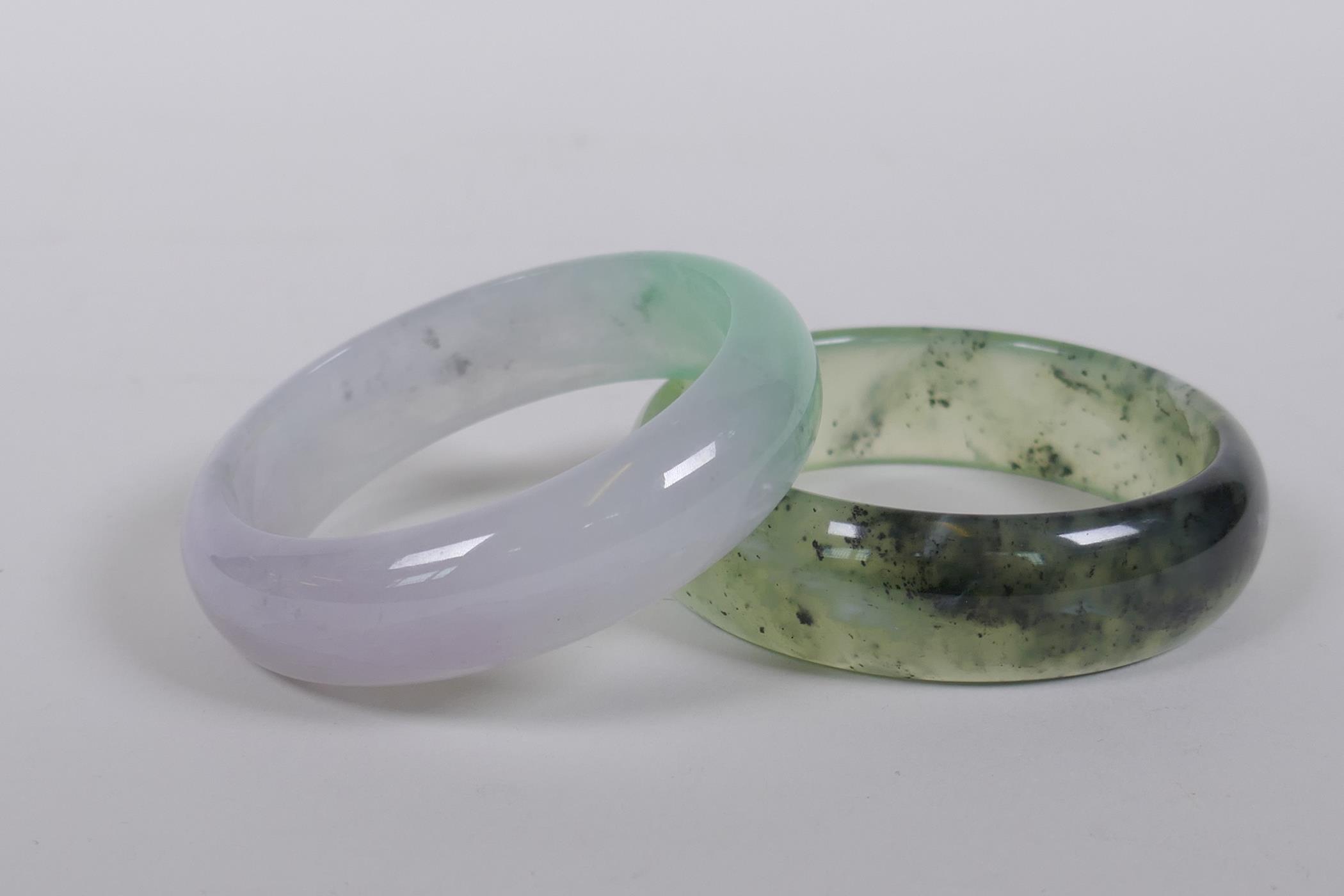 A bi-colour jade bangle, and another, 7cm diameter