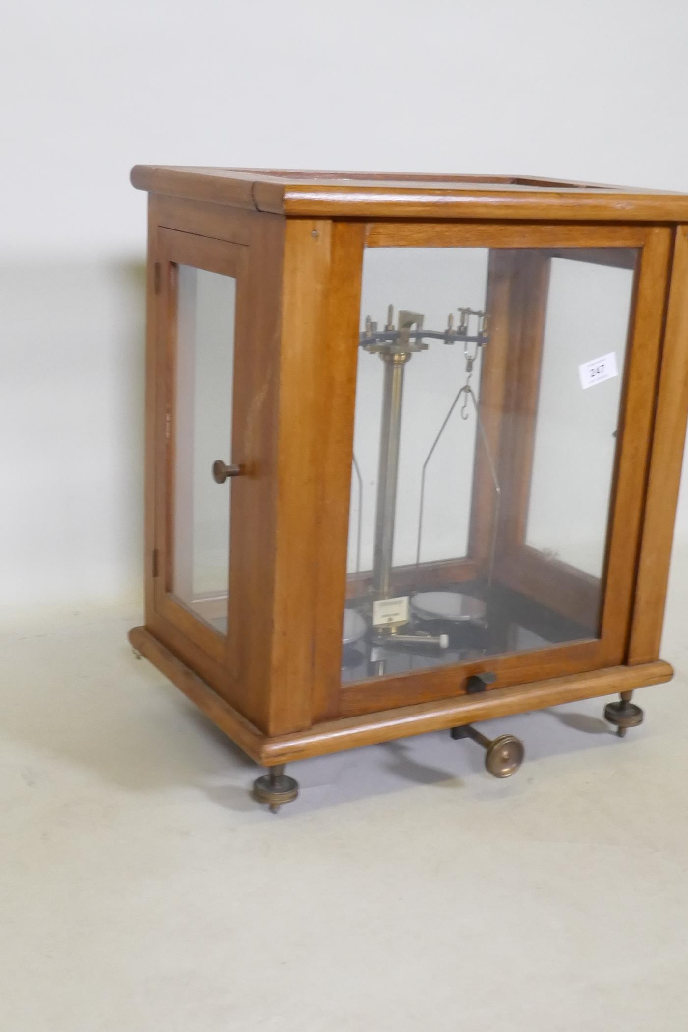 A set of balance scales in a glazed wood cabinet, 43 x 30 x 50cm - Image 2 of 3