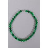 A Chinese apple green hardstone bead necklace, 44cm long