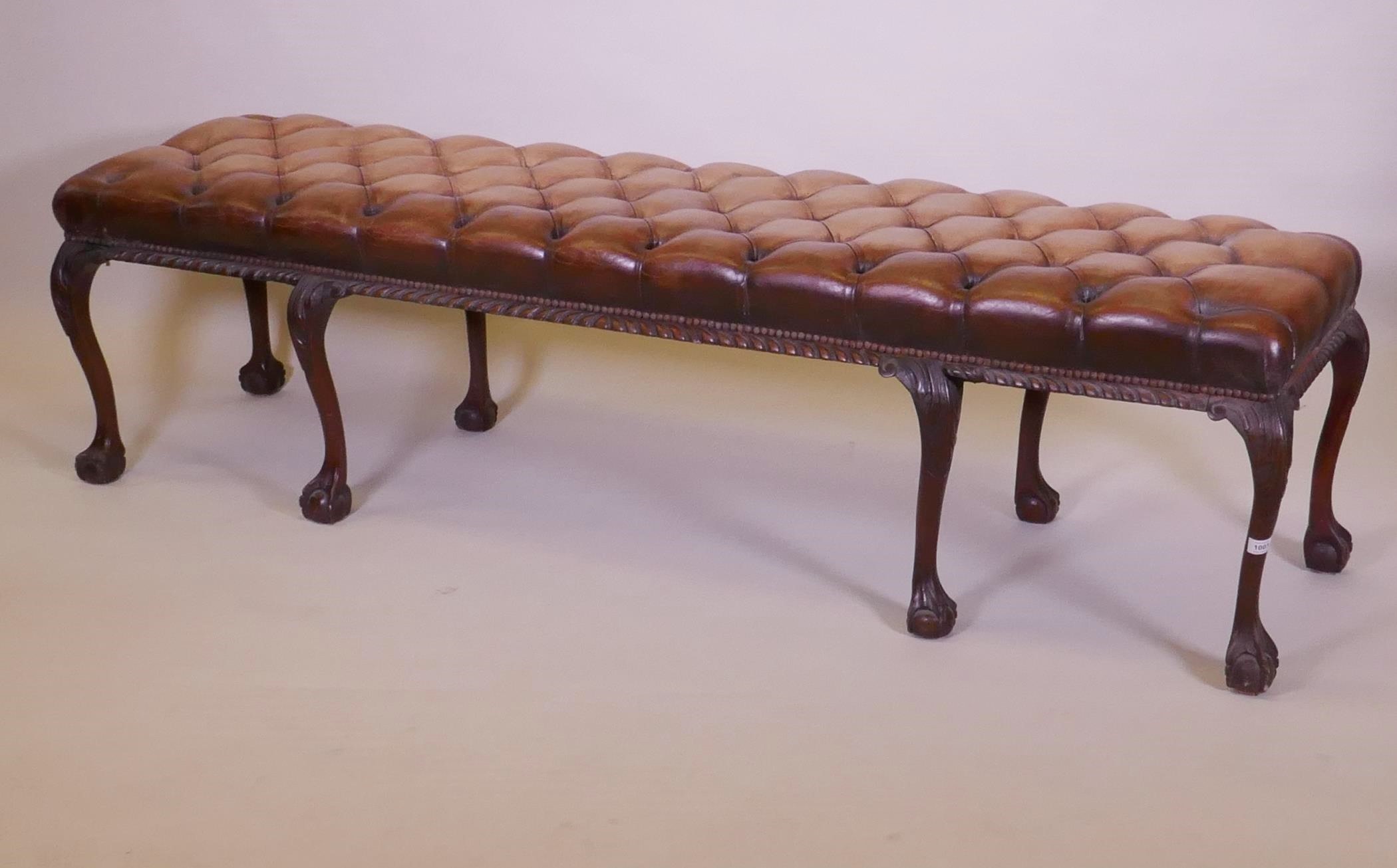 A mahogany bench raised on cabriole legs with claw and ball feet and a buttoned leather seat, 192