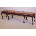 A mahogany bench raised on cabriole legs with claw and ball feet and a buttoned leather seat, 192