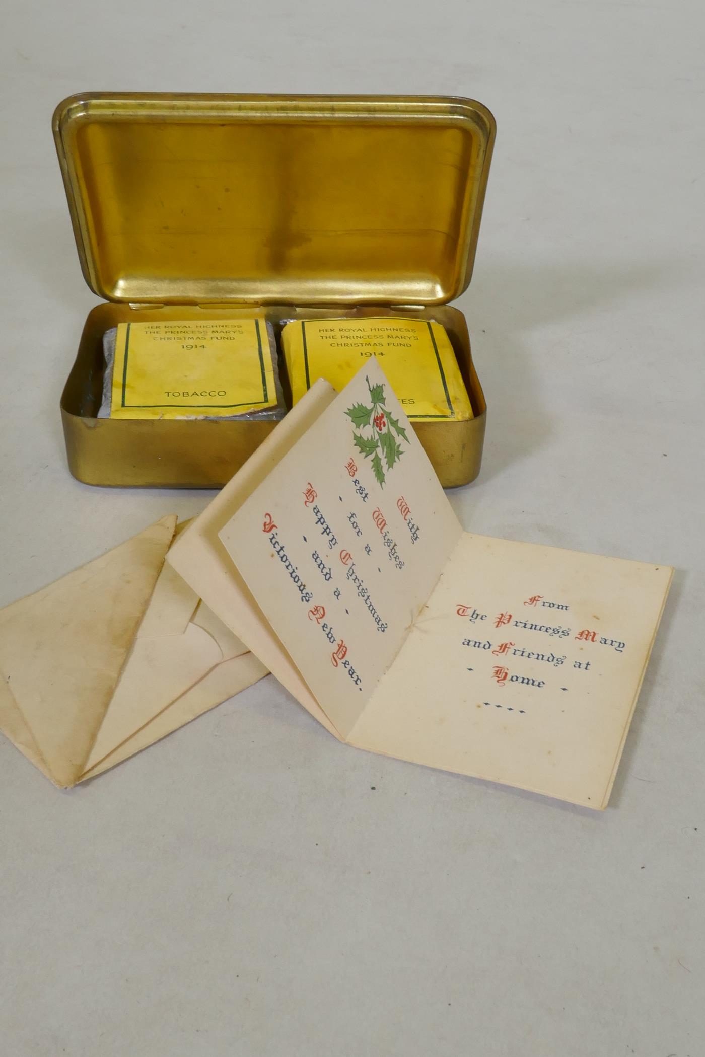 A WWI Christmas 1914 Princess Mary gift tin, with cigarettes and unopened tobacco, and greetings