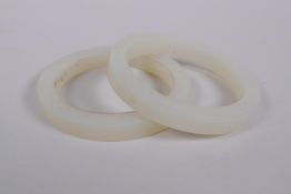 Two white hardstone bangles, 7cm diameter