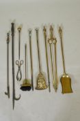A set of three brass Empire style fire irons and a quantity of other fire irons including a