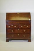 A Georgian mahogany bureau with two short over two long drawers, the full front fitted with pigeon