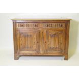 A mid century oak dresser with dome shaped upper rack on a base of two drawers over two cupboards,