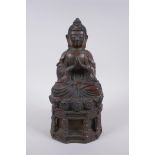 A Chinese bronze figure of Buddha seated on a throne with the remnants of gilt patina, character