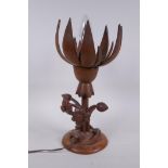 A carved wood lotus flower table lamp, the petals opening to reveal the bulb, 35cm high