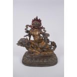 A Sino Tibetan gilt bronze figure of a wrathful deity seated on a kylin, impressed double vajra mark