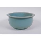 A Chinese ru ware style porcelain steep sided bowl with twin mask handles, 18cm diameter