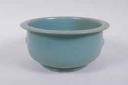 A Chinese ru ware style porcelain steep sided bowl with twin mask handles, 18cm diameter