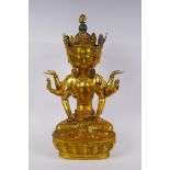 A large Sino Tibetan gilt bronze figure of a deity with many arms and faces, impressed double