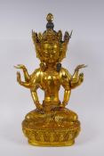 A large Sino Tibetan gilt bronze figure of a deity with many arms and faces, impressed double