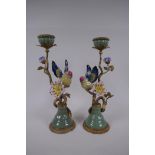 A pair of polychrome porcelain and gilt metal candlesticks decorated with birds and flowers, 32cm
