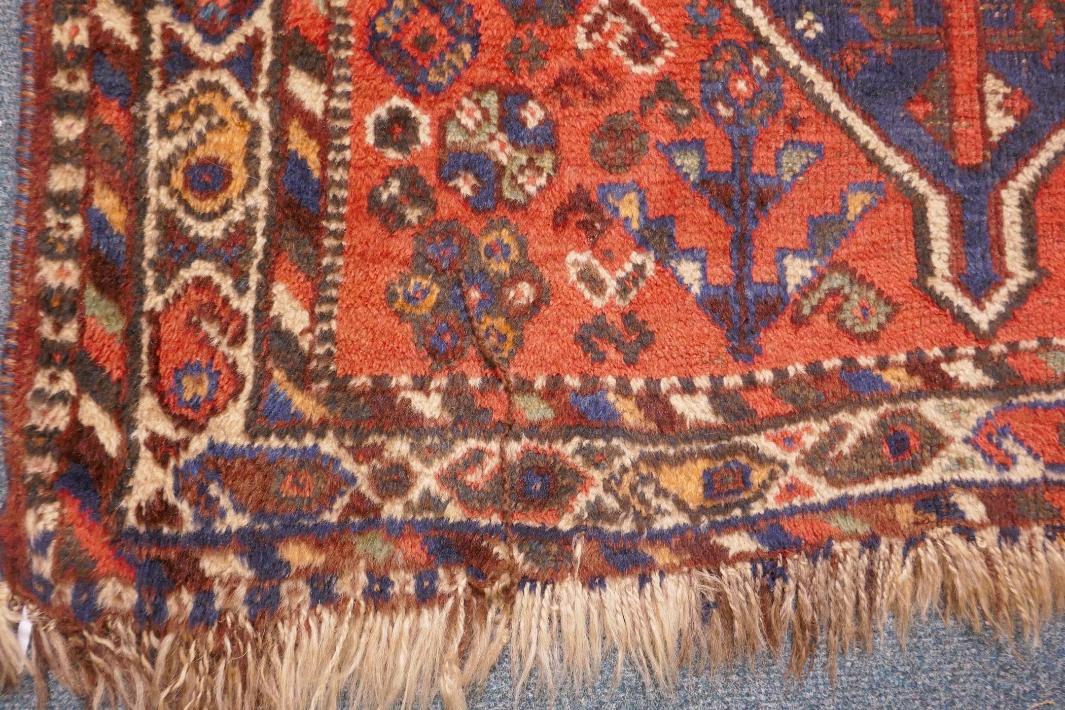An antique Persian wool rug, with twin blue ground medallions on a tomato field, 124 x 92cm - Image 3 of 4