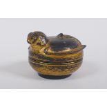 An antique oriental gilt and black lacquer box in the form of a bird, 9cm diameter