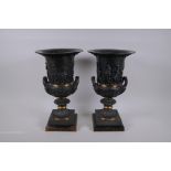 A pair of Grand Tour style bronze two handled urns, with figural decoration and brass bands, mounted