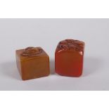 A Chinese amber soapstone seal with Buddha head decoration, and another similar, 3 x 3cm