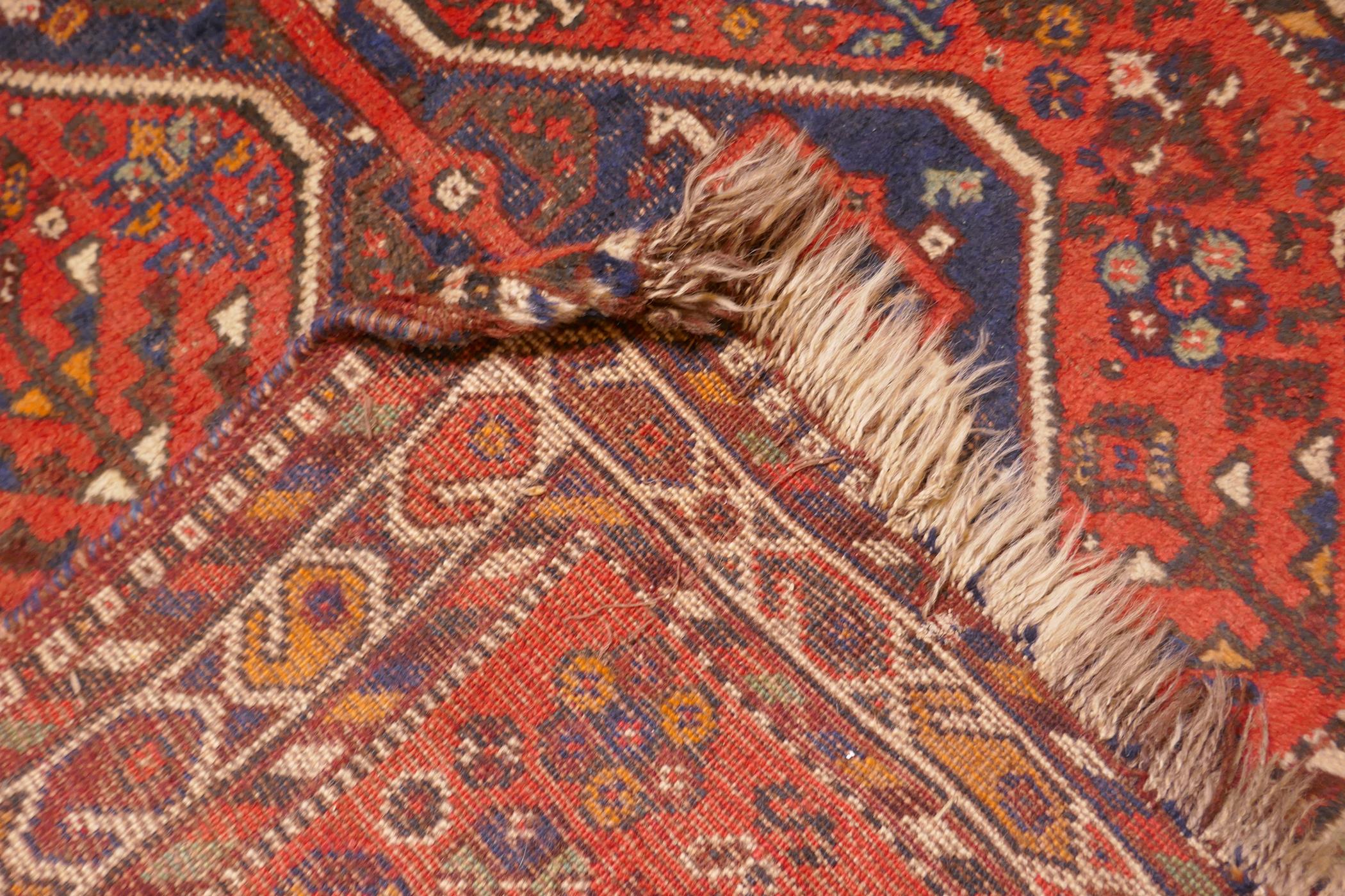 An antique Persian wool rug, with twin blue ground medallions on a tomato field, 124 x 92cm - Image 4 of 4