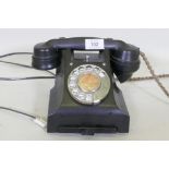 A vintage black bakelite telephone with pull out slide