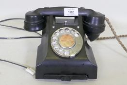 A vintage black bakelite telephone with pull out slide