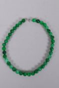 A Chinese apple green hardstone bead necklace, 44cm long