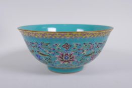 A Chinese turquoise ground porcelain bowl with polychrome enamel lotus flower decoration, Qianlong