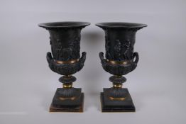 A pair of Grand Tour style bronze two handled urns, with figural decoration and brass bands, mounted