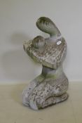 A stylised carved stone figure of a kneeling mother and child, AF, 79cm high