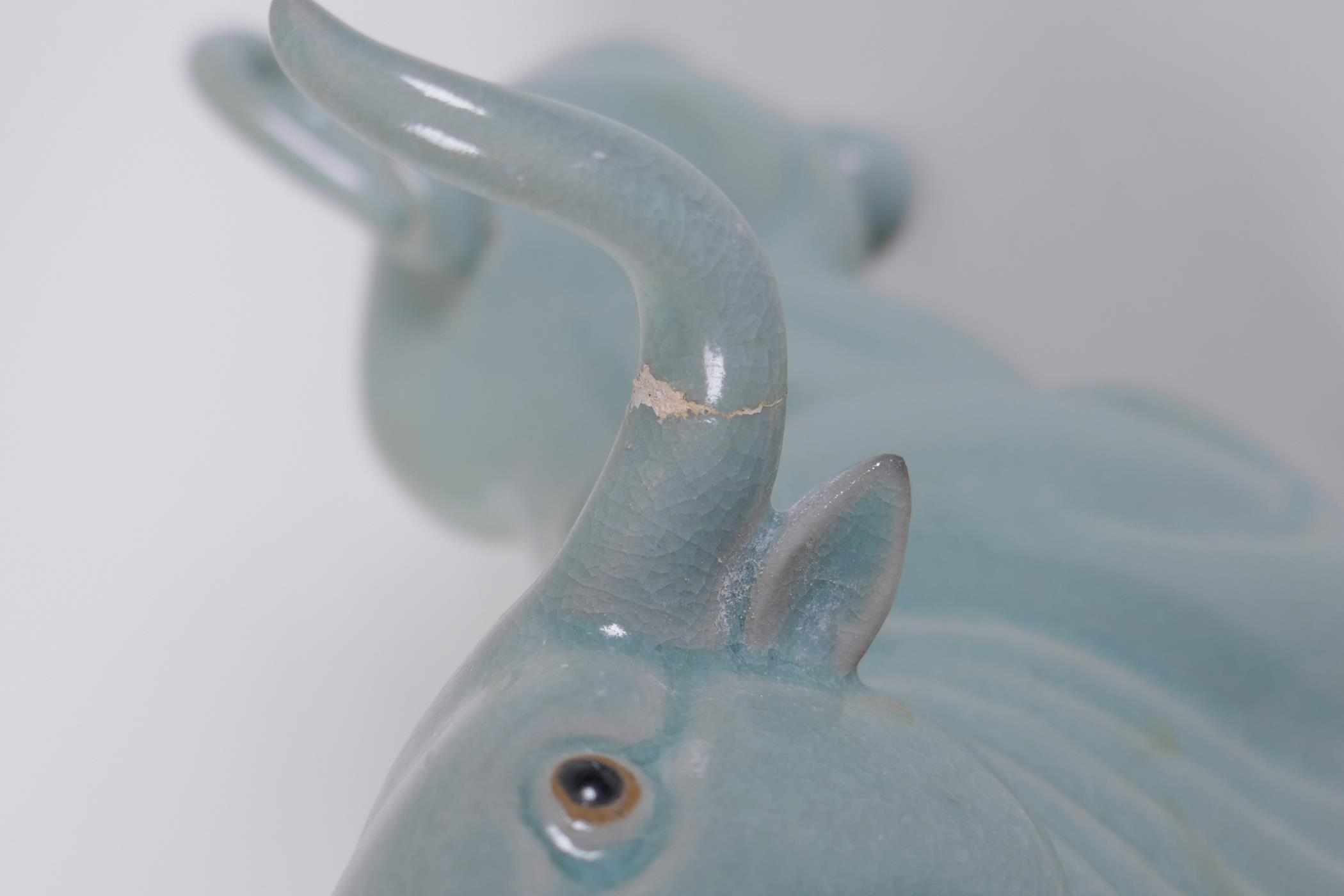 A Chinese celadon glazed porcelain figure of a buffalo, AF repair, 22cm long - Image 4 of 5