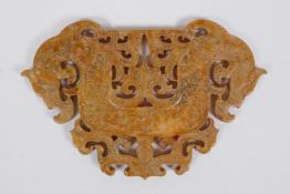 A Chinese carved and pierced hardstone pendant with stylised twin dragon decoration, 14 x 9cm