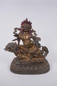 A Sino Tibetan gilt bronze figure of a wrathful deity seated on a kylin, impressed double vajra mark