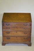 A Geogrian oak fall front bureau with fitted interior over three drawers, raised on bracket supports